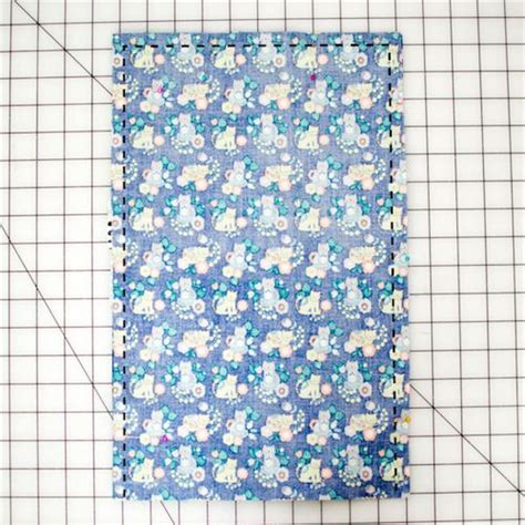 A Piece Of Fabric With Flowers On It Next To A Ruler And Some Sewing Thread