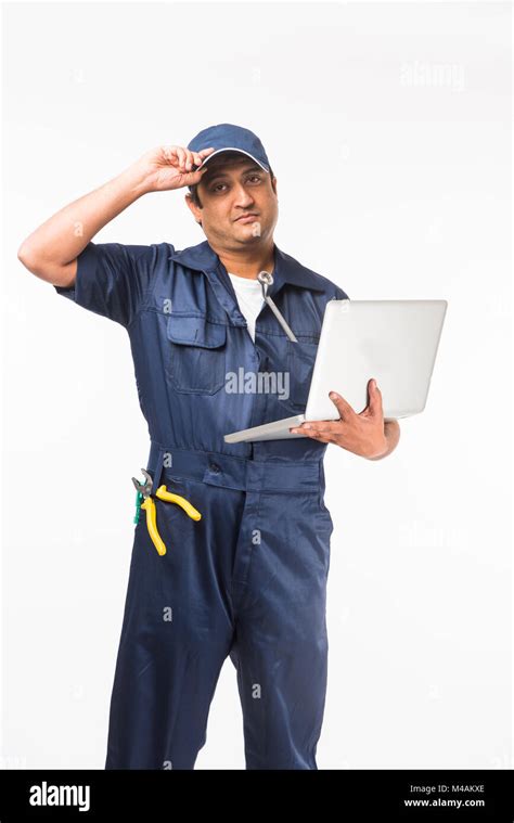 Indian Happy Auto Mechanic In Blue Suit And Cap Holding Spanner Tool In