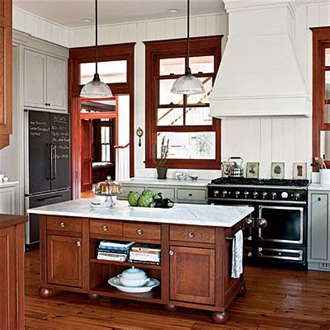 Darker wood floor with lighter wood trim and gray walls. Wood trim kitchen with grey cabinets, wood island lower ...