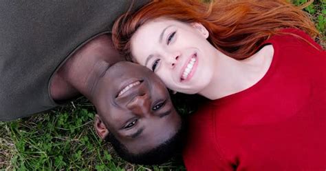 Smiling Interracial Young Couple Lying On Lawnhappy Mixed Race Couple