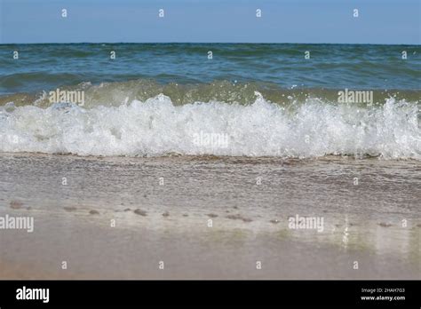 Foamy Sea Waves Roll On The Sandy Daytime Beach Stock Photo Alamy