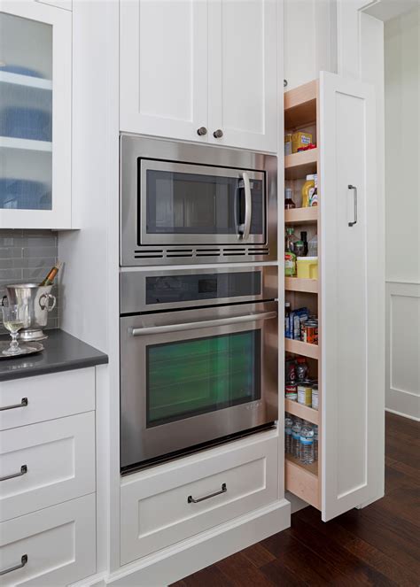 A Stainless Steel Oven And Microwave In A White Kitchen With Wood