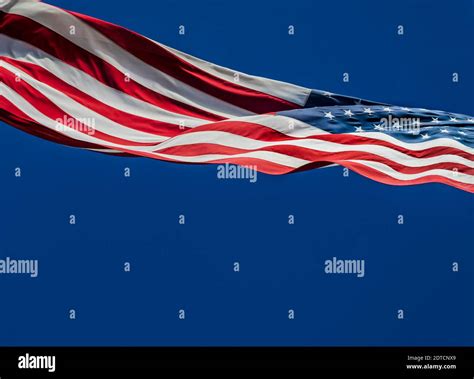 American Flag Blowing In Wind Against Blue Sky Stock Photo Alamy