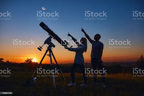 Couple Stargazing Together With A Astronomical Telescope Stock Photo