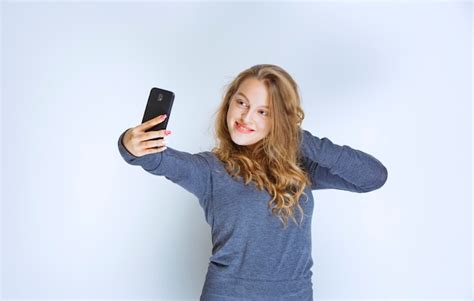 free photo blonde curly haired girl taking her selfie