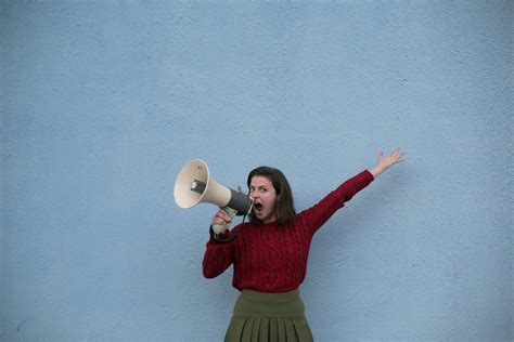 Angry Woman Yelling Into Loudspeaker On Blue Background · Free Stock Photo