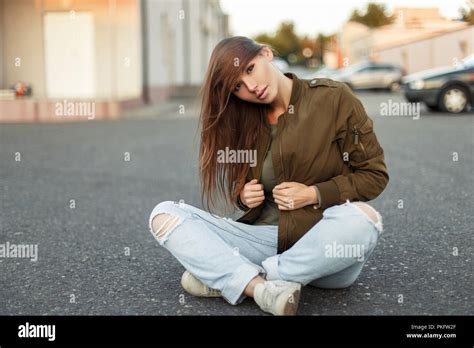 Beautiful Vogue Woman In A Fashionable Jacket And Torn Jeans On The
