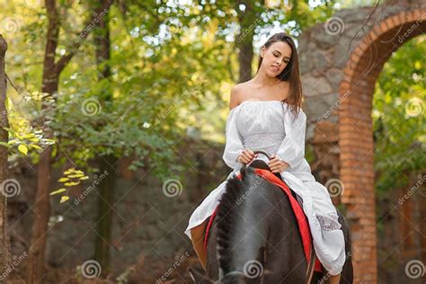 Horseback Riding Beautiful Young Woman In A White Dress Riding On A