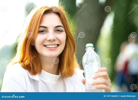 Thirsty Smiling Redhead Woman Drinking Water From A Bottle In Summer Park Stock Image Image Of