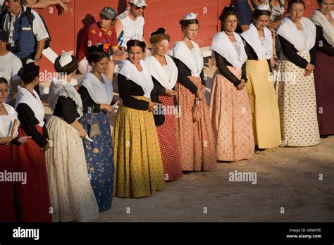 A row of women standing in the Arena dressed in Arlésienne costume ...