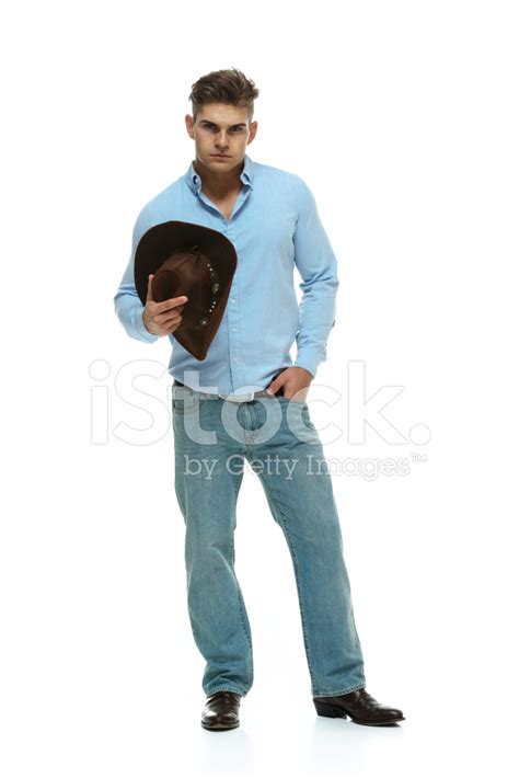 Cowboy Holding Hat And Looking At Camera Stock Photo Royalty Free