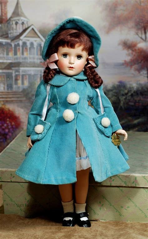 The Doll Is Wearing A Blue Coat And Hat