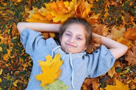 Girl Having Holiday In Autumn City Park Lying On Grass Posing