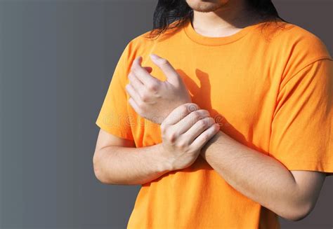 Young Men Suffering From Arm Pain And Chronic Wrist Pain Stock Photo