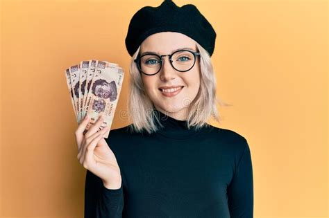 Young Blonde Girl Holding Mexican Pesos Looking Positive And Happy