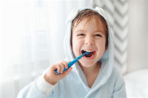 Premium Photo Portrait Of Smiling Happy Child Brushing Teeth With