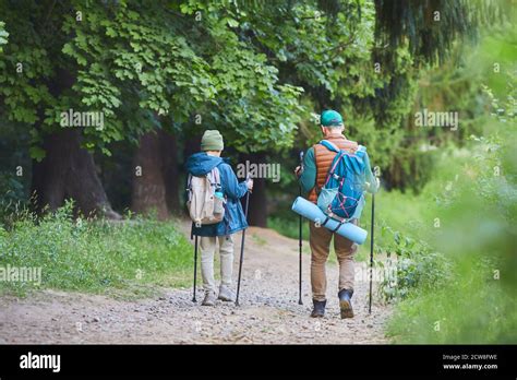 Full Length Back View Portrait Of Father And Son Hiking Together