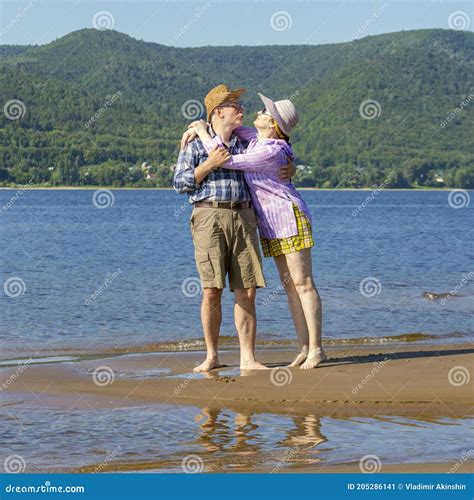 Beautiful Mature Couple Hugging And Kissing On A Sandy Beach On A Summer Sunny Day Stock Image