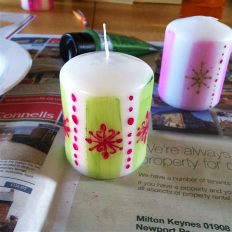 Two Candles Sitting On Top Of A Newspaper