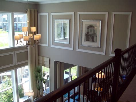A Staircase With Pictures On The Wall And Chandelier In Front Of Its