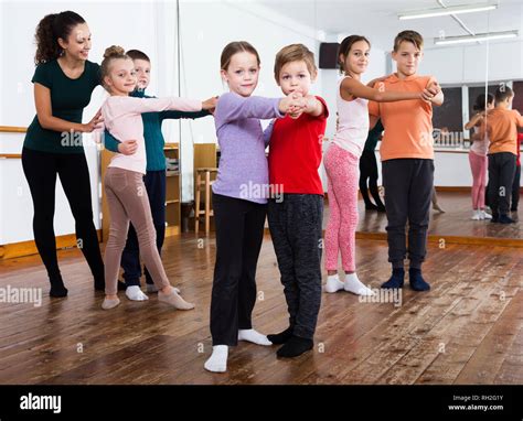Group Of Children With Female Teacher Dancing Pair Dance In Dance Class