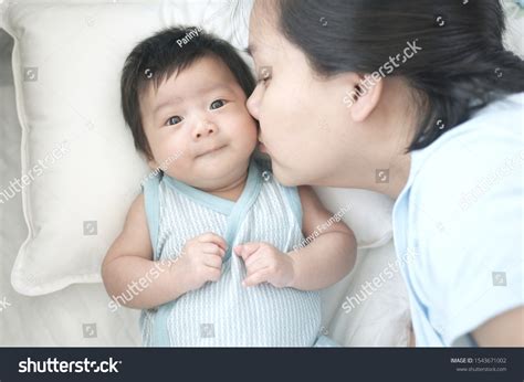 Young Asian Mother Kissing Baby On Stock Photo Edit Now 1543671002