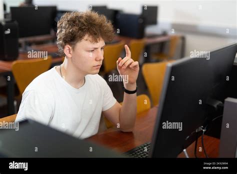 Focused Puzzled Teenage Boy Studying In Computer Lab Stock Photo Alamy