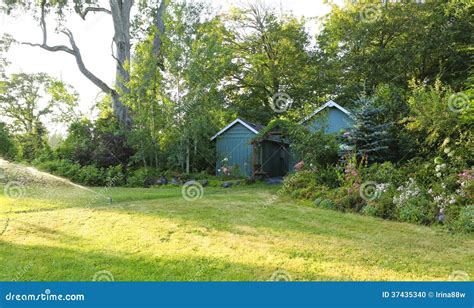 Flourishing Farm Backyard With Sheds And Garden House Stock Photo