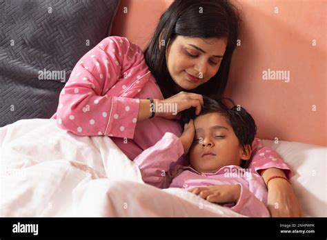 Mother Caressing Her Sleeping Son On Bed Stock Photo Alamy