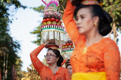 Procession Of Balinese Women In Traditional Sarongs Carrying Religious