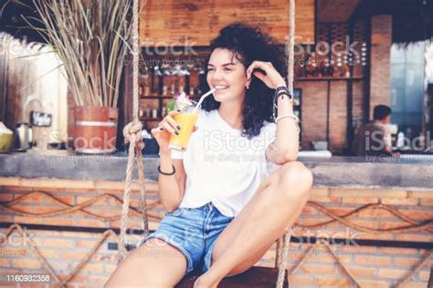 Beautiful Young Slim Woman With Dark Curly Hair In Denim Shorts With