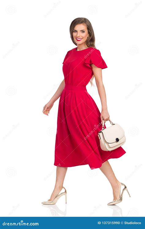 Walking Beautiful Woman In Red Dress Gold High Heels And Beige Purse