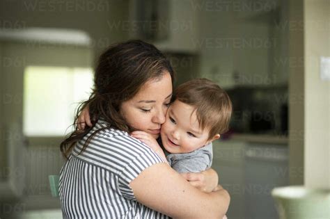 Affectionate Mother Hugging Toddler Daughter Stock Photo