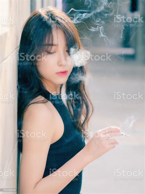 美麗的中國女孩的肖像戶外吸煙和思考問題 似乎有點失落 在老式模式 照片檔及更多 一個人 照片 Istock