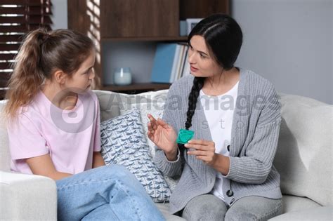 Mother Talking With Her Teenage Daughter About Contraception At Home Sex Education Concept