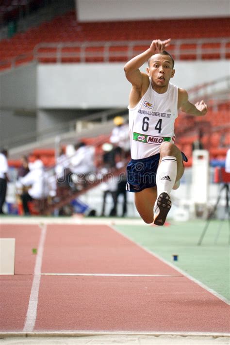 The competitor runs down the track and performs a hop, a bound and then a jump into the sand pit. Triple salto foto de archivo editorial. Imagen de corrida - 4433883