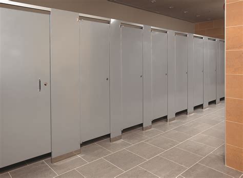 A Row Of Stalls In A Public Restroom With Tile Flooring And Walls Lined