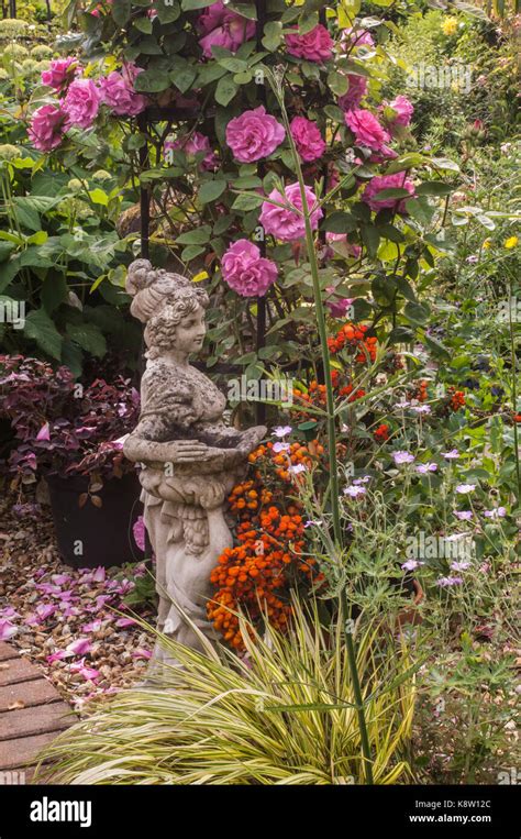 Romantic Garden Statue With Roses Stock Photo Alamy