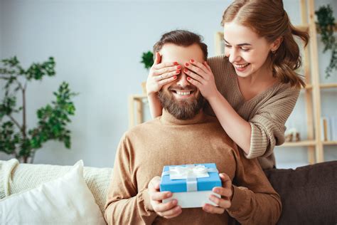 Happy Married Couple Man And Woman Give A Gift For Holiday The World