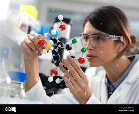 Female Scientist Designing A Chemical Formula Using A Ball And Stick