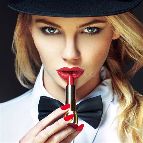 femme blonde sexy avec les lèvres rouges et les clous appliquant le rouge à lèvres image stock