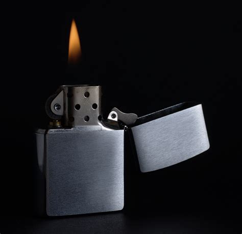 Feuerzeug im grauen design, mit aufgedrucktem leuchtturm. Zippo - einebinsenweisheit