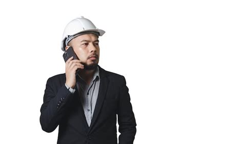 흰색 배경 클리핑 패스에 격리된 휴대전화를 말하는 안전모를 쓴 아시아 엔지니어링 남자 프리미엄 사진