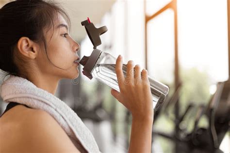 Young Fitness Woman Is Drinking Water After Exercise Workout At Gym