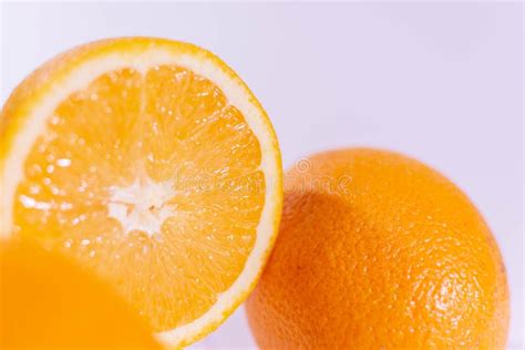 Halved Orange Near A Whole Orange On A White Background Stock Photo