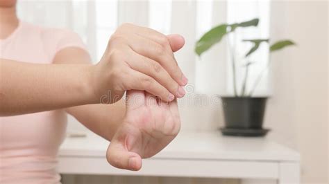 Asian Woman Is Stretching And Gently Pulling Her Fingertips In Doing Physical Therapy Stock