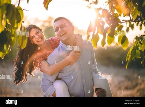 Outdoor Portrait Of Young Couple Boyfriend Carrying Girlfriend On His
