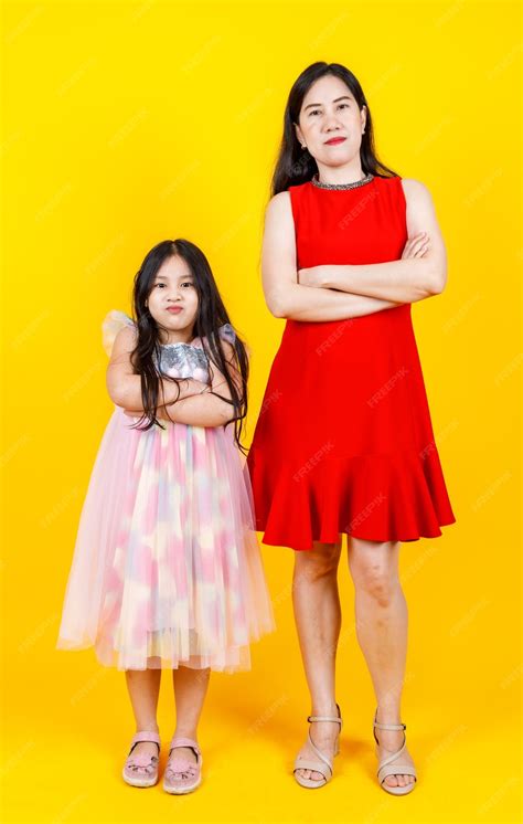 Premium Photo Asian Mom And Daughter Taking Portrait Photo Together On Yellow Background With