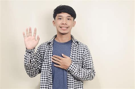 Premium Photo Cheerful Asian Man Waving To Say Hello On Isolated