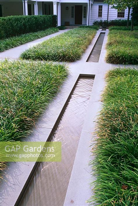 Contemporary Water Rill With Grasses Paths And House In Background
